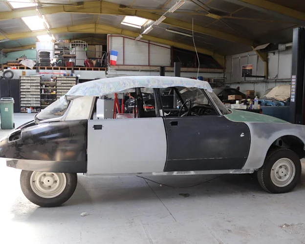 Citroën DS en cours de rénovation dans un garage, vue latérale à Gargenville près de Mantes-la-Jolie dans les Yvelines 78