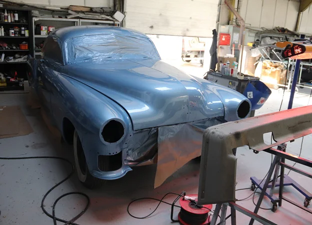 Voiture bleue vintage en cours de restauration dans un garage à Gargenville près de Mantes-la-Jolie dans les Yvelines 78